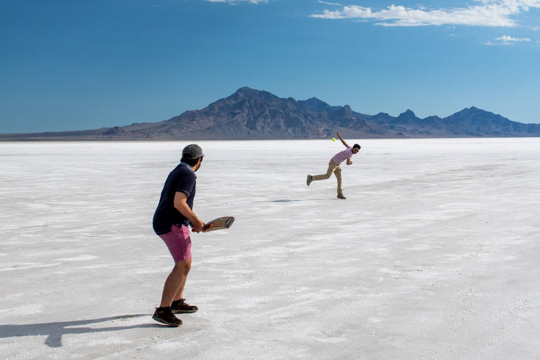 A couple of people that are standing in the sand