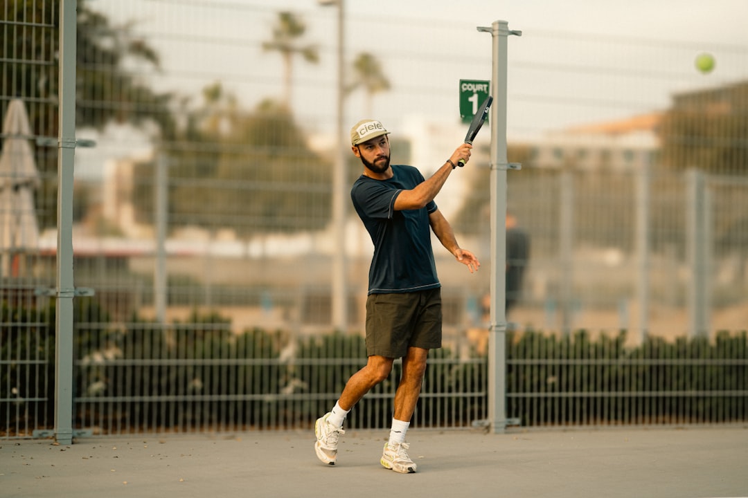A man swinging a tennis racquet at a tennis ball