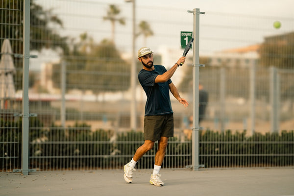 A man swinging a tennis racquet at a tennis ball