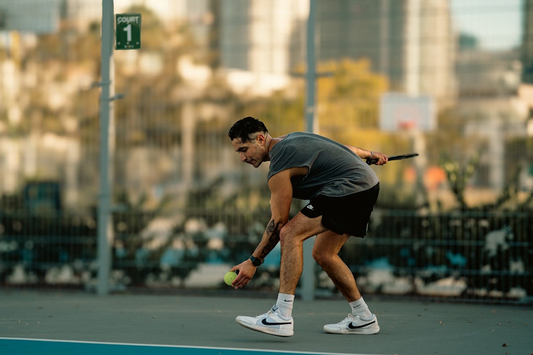 A man holding a tennis racquet on top of a tennis court
