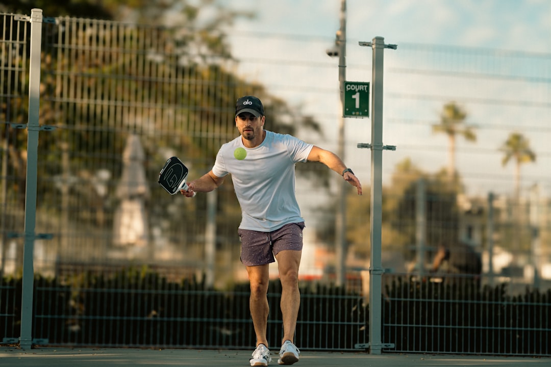 A man holding a tennis racquet on top of a tennis court