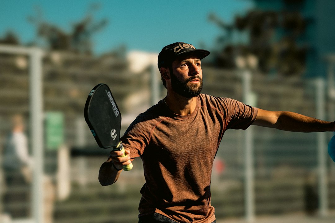 A man holding a tennis racquet on top of a tennis court