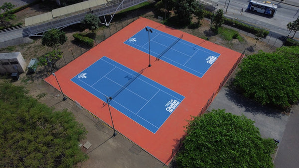 Two blue tennis courts with orange surrounds.