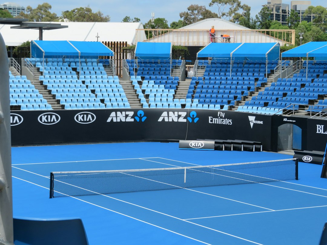 A blue tennis court with rows of empty blue seats in Melbourne, Australia